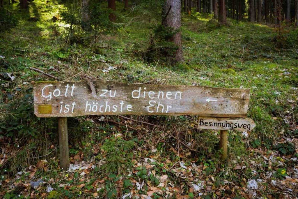 Holzbank mit Sinnspruch entlang des Besinnungswegs Achensee im Wald