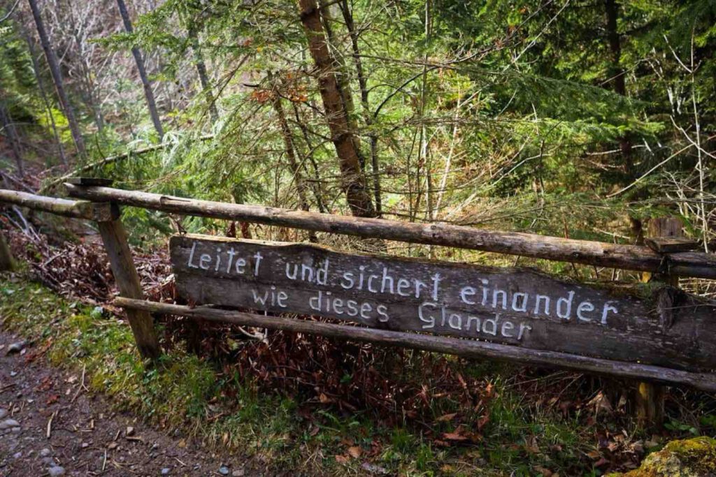 Holzbank mit Sinnspruch entlang des Besinnungswegs Achensee im Wald