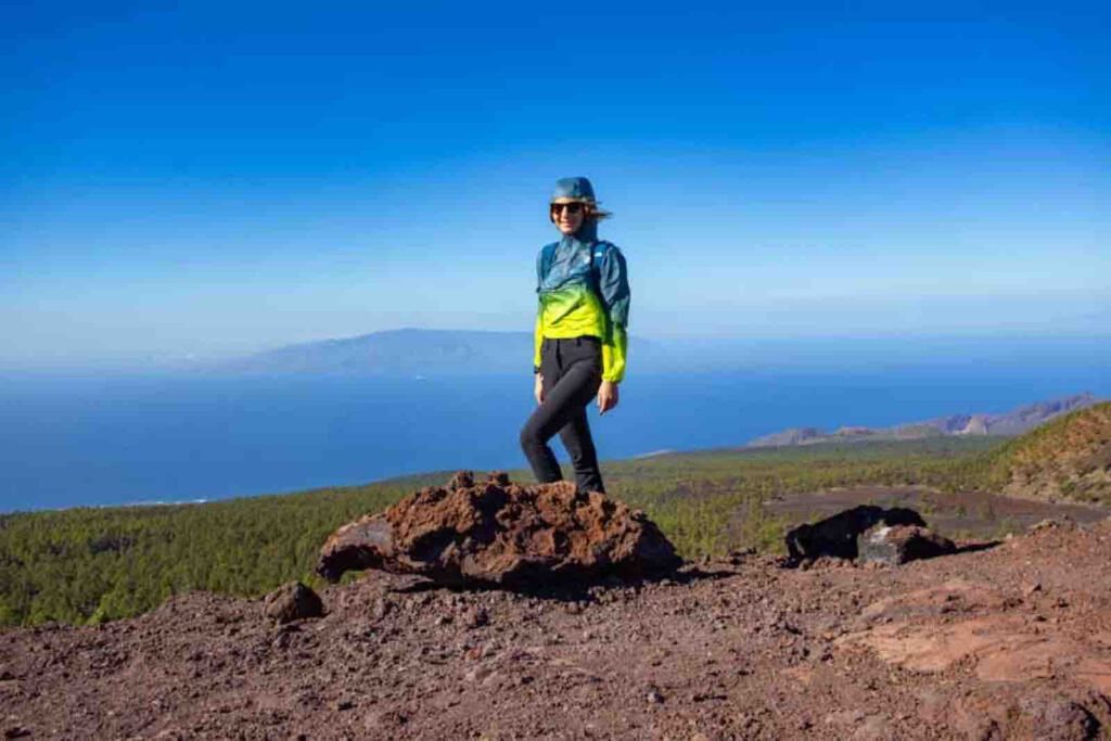 Wanderin Christin Großheim auf einem Felsen mit Blick auf die Vulkanlandschaft im Teide Nationalpark bei der Montaña Samara