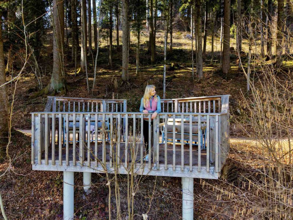 Holzplattform mit Sitzbänken im Wald bei Söll