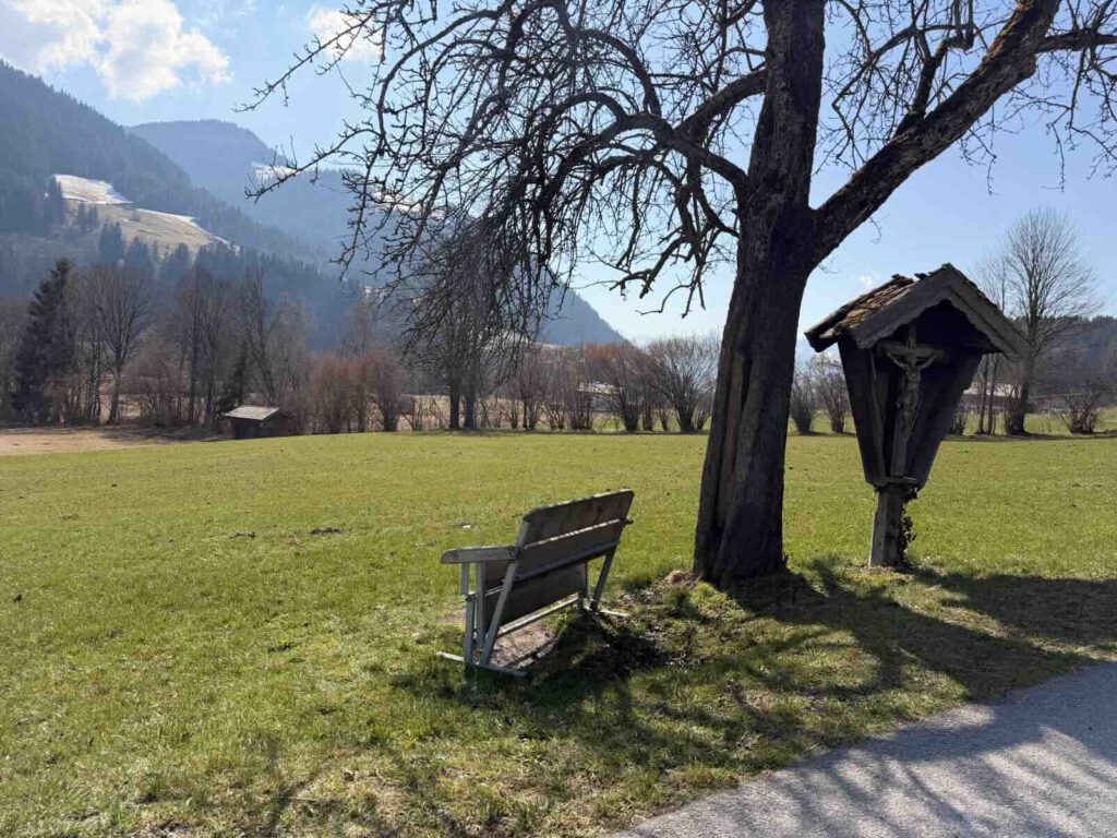 Bank mit Aussicht auf Wiesen und Berge in Söll