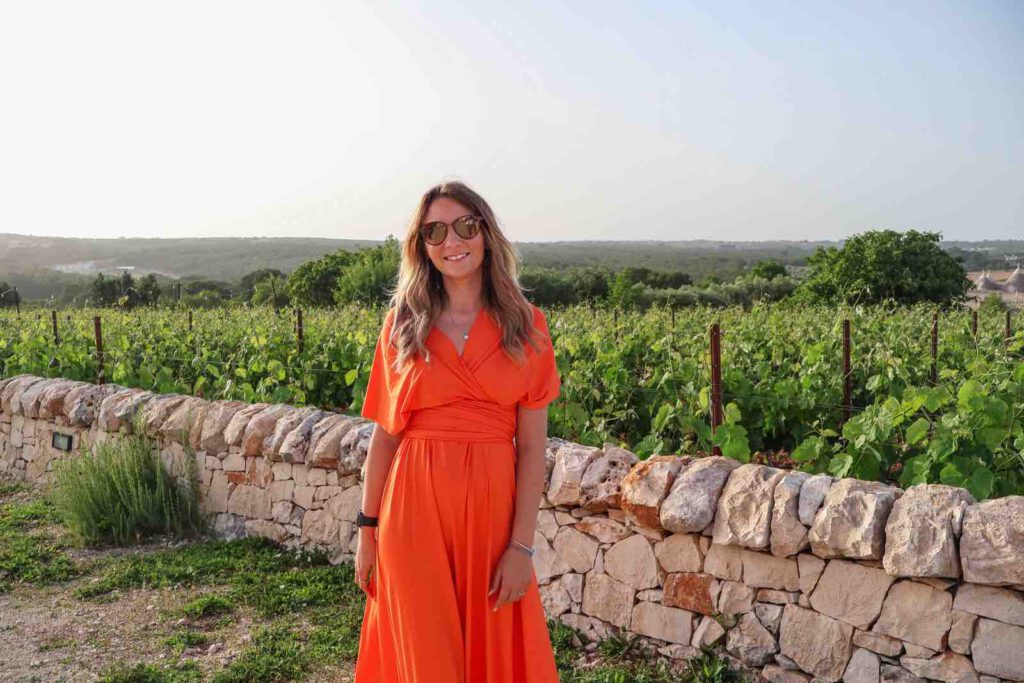 Puglia dei Trulli, Christin Großheim im orangenen kleid weinberg apulien martina franca
