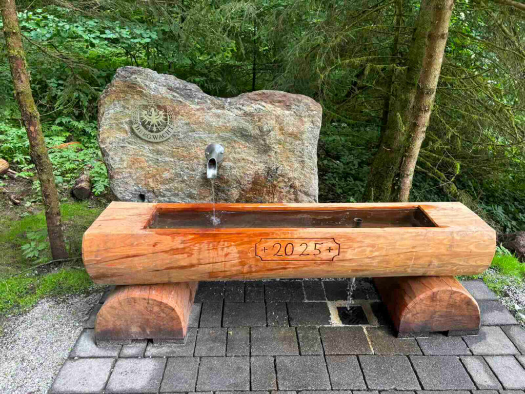 Holzbank am Moorsee Söll mit geschnitztem Stein